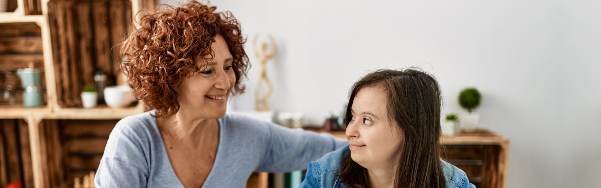 a woman and a girl smiling at each other