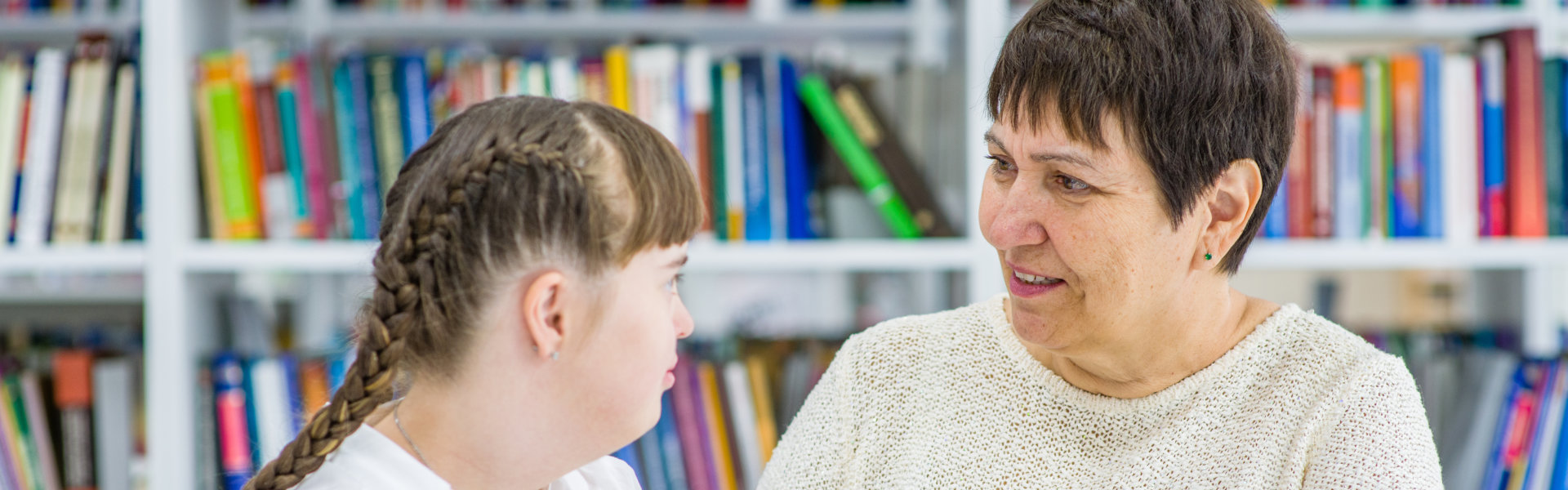 a woman talking to a little girl