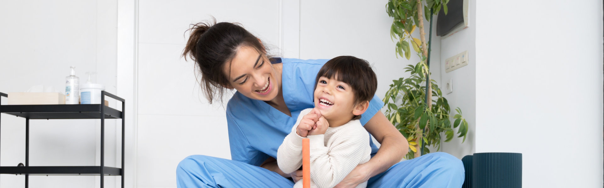 a female caregiver with a boy smiling